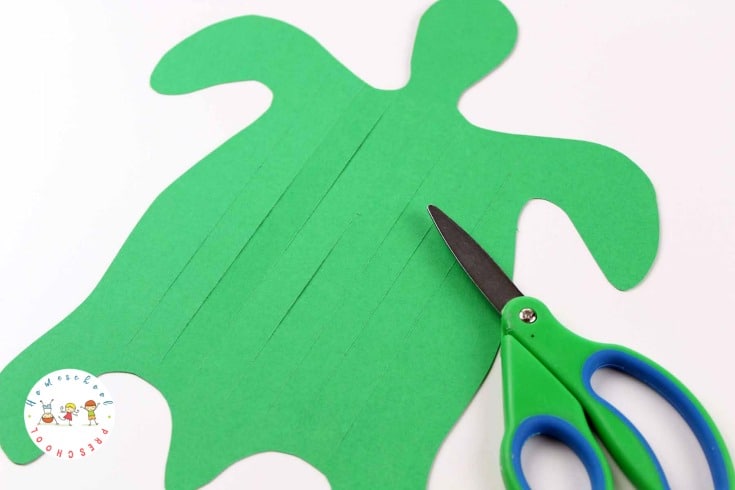 green DIY sea turtle craft template with slits cut in it